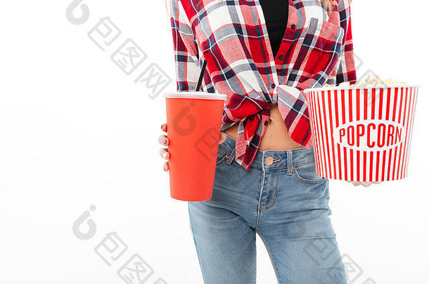 特写镜头：一个穿着格子衬衫的女孩拿着爆米花和一个塑料杯，在白色背景上隔离开来