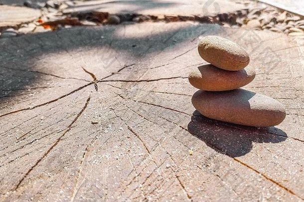 瑜伽禅石相互平衡。海卵石躺在一把被太阳照亮的木锯上。空间。