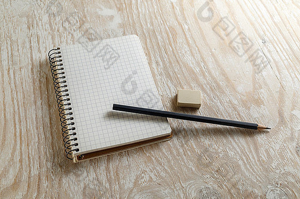 在浅色木质背景上用铅笔和橡皮擦做成的记事本