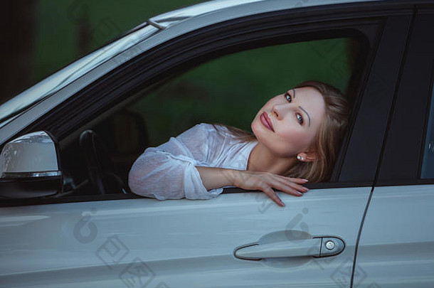 那个女人在车窗里，她愉快地微笑着。