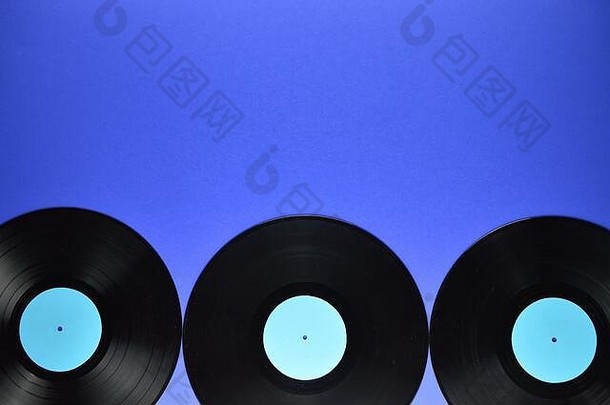 蓝色背景上带有空白青色标签的旧黑色乙烯基唱片边框