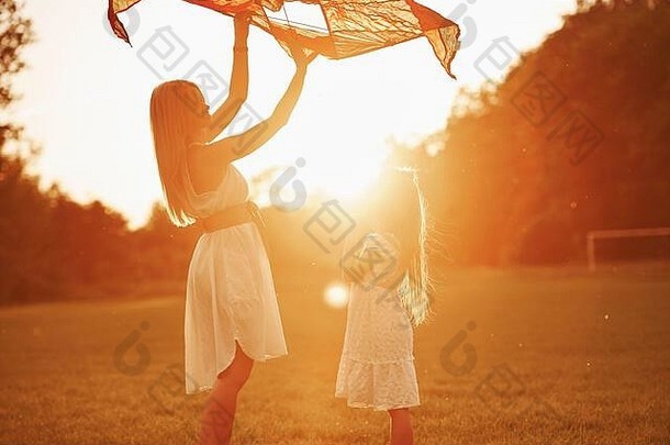 它会飞起来的。妈妈和女儿在田野里玩<strong>风筝</strong>。美丽的自然