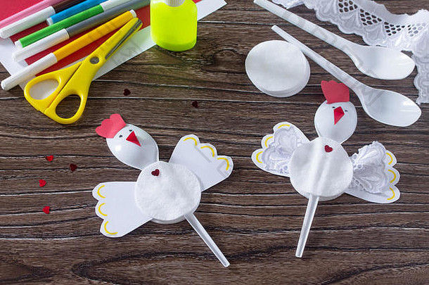 小公鸡创造了一个<strong>圣诞</strong>礼物玩具的<strong>圣诞</strong>玩具。胶水、剪刀、纸、塑料勺放在木桌上。儿童的