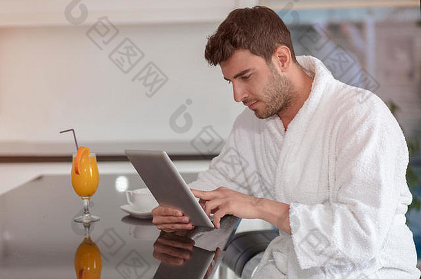 穿着浴衣在家使用平板电脑的年轻自由职业者