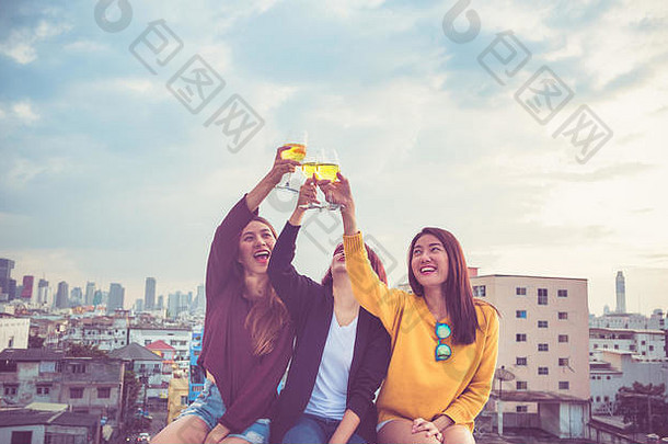 快乐亚洲女朋友团在屋顶派对上享受欢笑和愉快的吐司起泡酒杯，节日庆典，青少年生活方式，