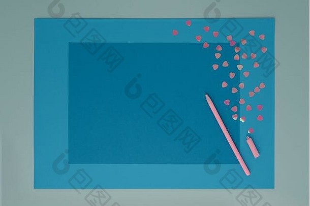 蓝色树层纸背景上的粉色心形和钢笔