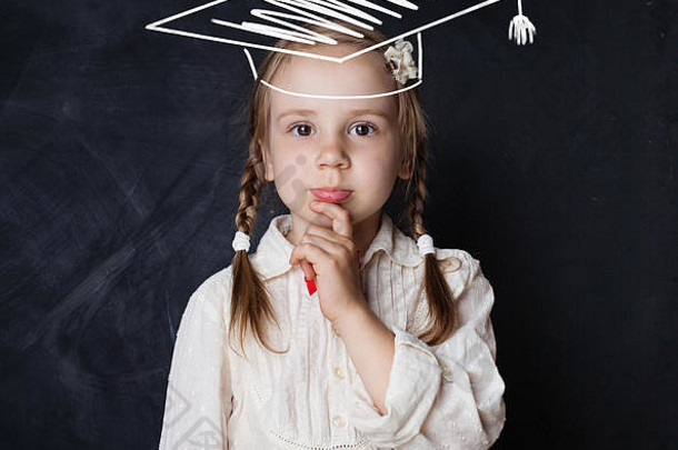 戴毕业帽的小女生在黑板旁思考