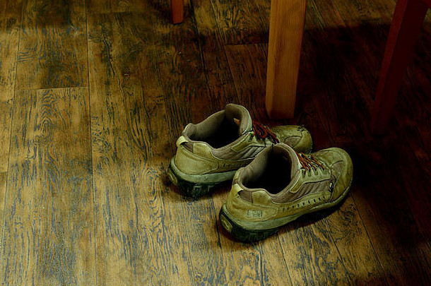 旧的脏安全鞋掉在木地板上