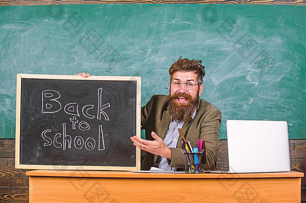 老师或校长用黑板题字欢迎回到学校。九月份新学年开始。老师欢迎新生进入教育机构。欢迎回来。