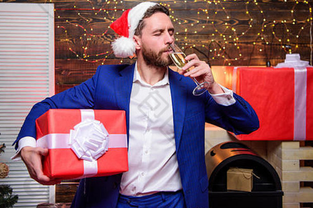 开朗的经理正式着装庆祝公司聚会。新年晚会。干杯新年快乐，圣诞快乐。大胡子商人用一杯香槟和礼盒庆祝新年。