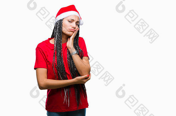 年轻的辫发非裔美国女孩，戴着圣诞帽，在与世隔绝的背景下思考，看起来很疲惫，对抑郁症感到厌倦