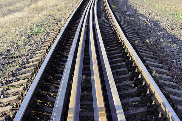 几根钢轨位于铁路主轨之间的轨枕上。沿铁路方向将钢轨固定至轨枕的螺栓