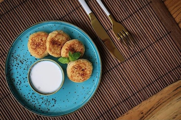 蓝色盘子上的纯素豆腐奶酪煎饼，配新鲜热带水果和椰子奶油，俯瞰图