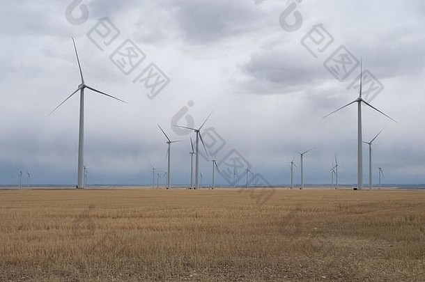草原上空灰色云层的风电场中有多个风力涡轮机。拍摄于蒙大拿州朱迪思盖普。