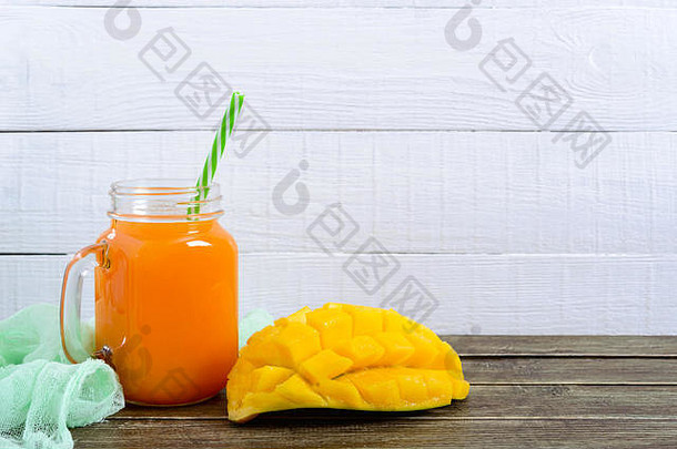 芒果奶昔玻璃Jar新鲜的芒果木背景芒果摇热带水果概念
