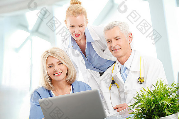 医疗队坐在电脑前的办公桌旁进行咨询的肖像。医疗组。