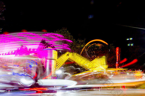 长曝光快旋转色彩斑斓的旋转木马照亮晚上生动的照明游乐场骑月公园