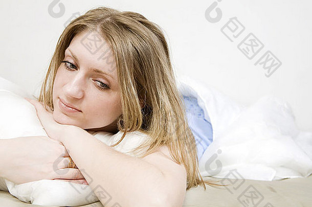 <strong>有</strong>吸引力的深思熟虑的金发碧眼的女人拥抱枕头床上女人问题