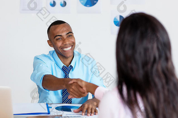 非裔美国商人在商务公司办公室签订合同后的握手