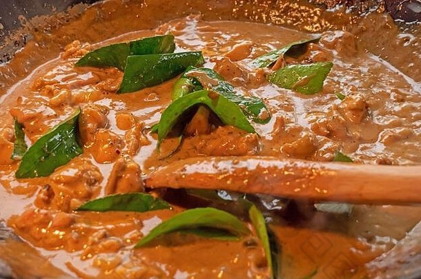 老板激起奶油酱汁泰国红色的鸡咖喱奶油椰子酱汁厨师蔬菜肉热锅