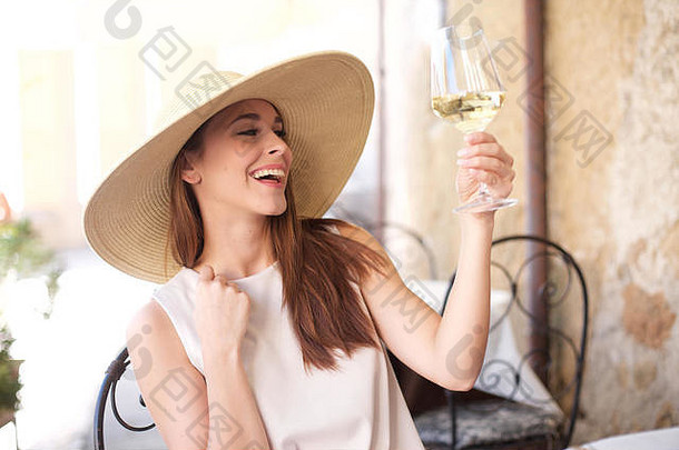 年轻的快乐女人玻璃白色酒
