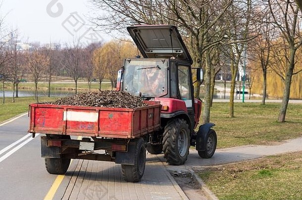 拖拉机驱动的树叶清洁城市街道，春天清洁城市街道