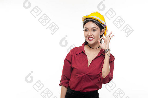 亚洲女工程师穿着红色衬衫，戴着黄色安全帽，行动<strong>自如</strong>。人们在商业和工程概念中做手势
