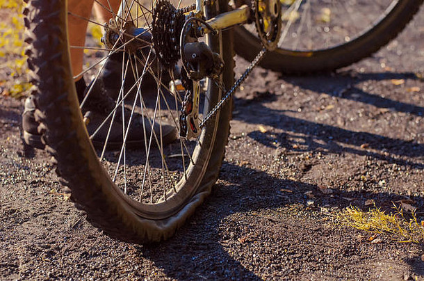 特写镜头：一辆运动自行车的后轮穿孔。在崎岖不平的地形上驾驶时出现问题。秋天的天气