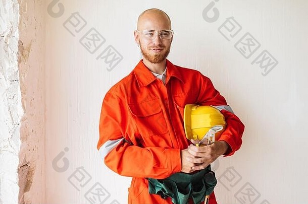 年轻的工头橙色工作衣服保护眼镜持有