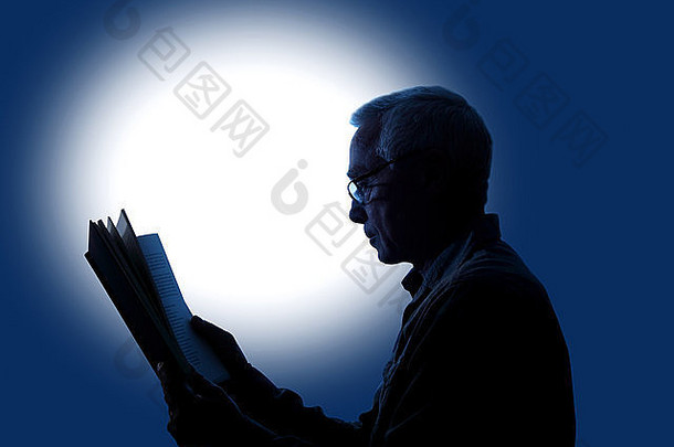 一个斑点背景，让一个大约60岁的男人一边戴着阅读眼镜一边看书