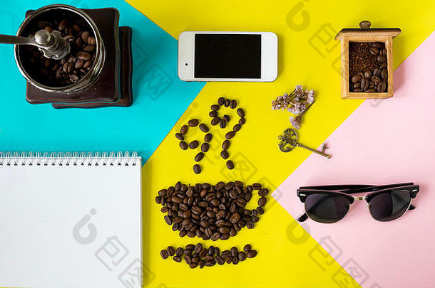 俯视图：咖啡豆呈杯形和气味图标形状，配有复古木制咖啡研磨机、手机、太阳眼镜和树形mult上的空白书