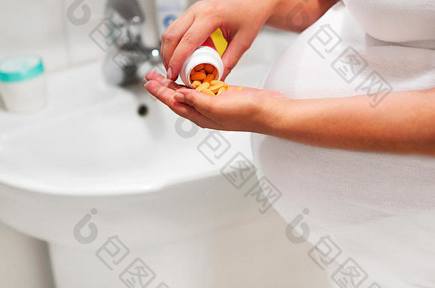 prgnant女人浴房间采取补充药片