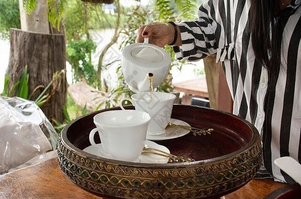 泰国度假酒店餐厅室外餐厅的餐厅露台上为游客和客人准备的茶点开胃菜和茶壶杯