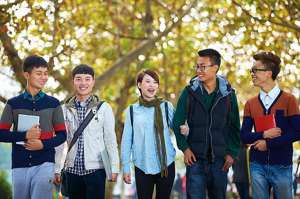 一群快乐的亚洲大学生一起走在校园里
