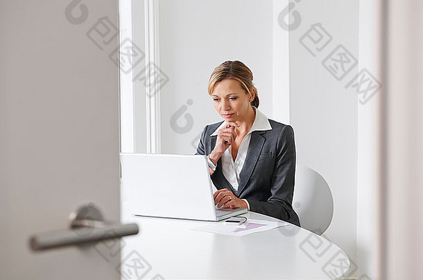 在办公室使用笔记本电脑的女商人
