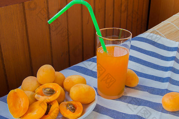 杏汁装在杯子里，餐巾纸上放着稻草和水果。
