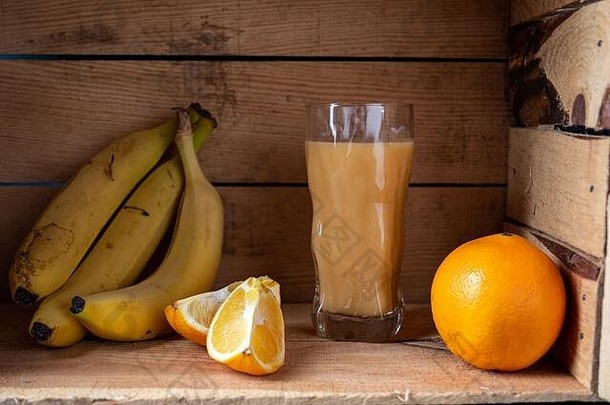 新鲜的香蕉和橙汁。装在木箱里的果汁和水果。