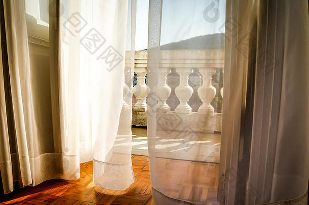 飘动的网状<strong>窗帘</strong>随风飘动，通向古老的欧洲酒店阳台，在克罗地亚的奥帕蒂亚营造出浪漫的氛围