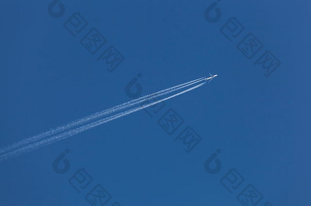 一架波音747在晴朗的蓝天上飞行时留下了蒸汽轨道