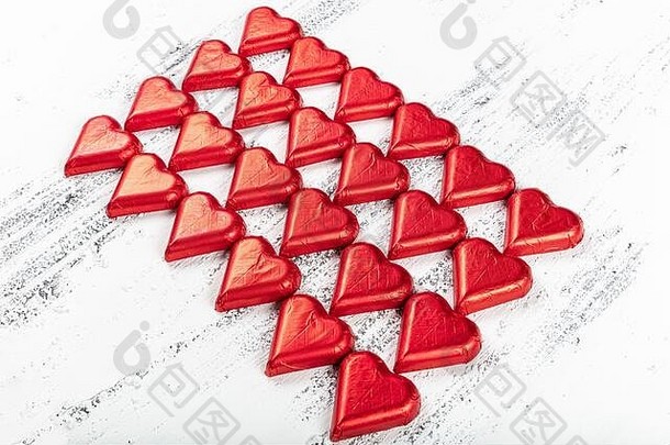 心形状的巧克力糖果包装红色的色彩斑斓的箔情人节一天情人节图像白色木背景