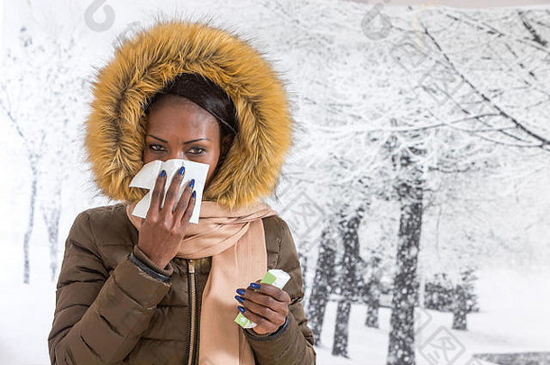 特写镜头肖像生病的年轻的非洲女人连帽外套皮毛吹鼻子冬天背景