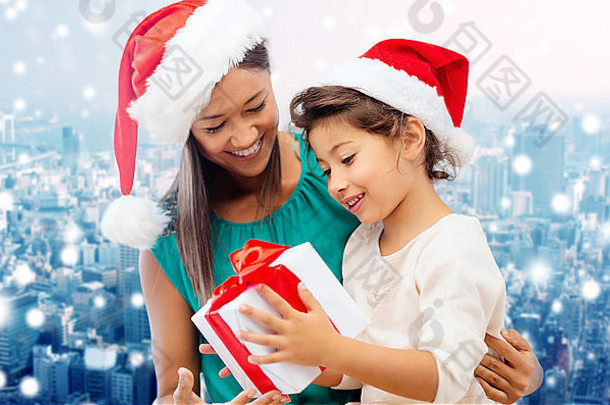 戴着圣诞帽的快乐妈妈和女孩，带着礼物盒