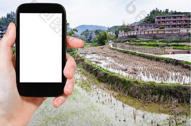 旅游理念-游客在中国三江侗族自治县城阳村拍摄的梯田照片，照片上的平板上有铜
