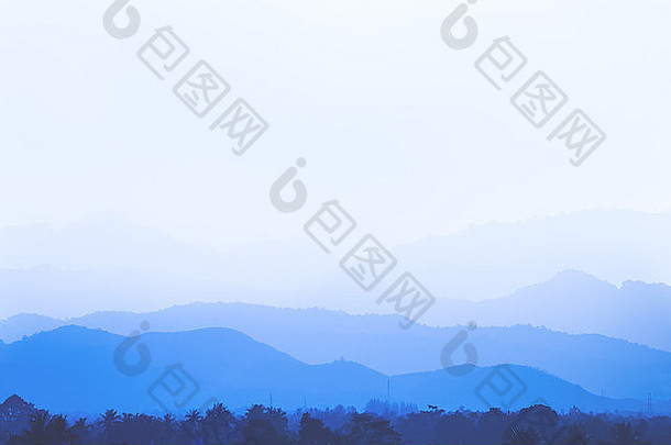 蓝色的山背景层覆盖软雾白色天空