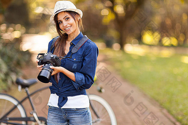 可爱的年轻的女摄影师相机在户外公园