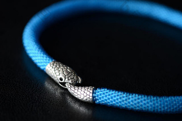 蓝色串珠项链，黑色背景特写，带蛇头锁