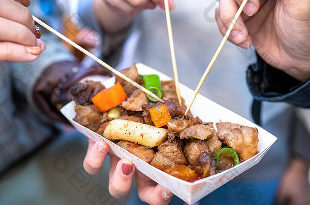 韩国传统市场上的油炸黑猪肉，美味的韩国美食，胡萝卜和葱，特写，空间