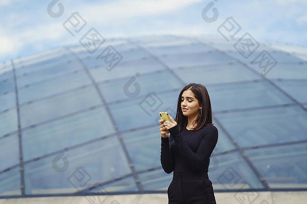 一个黑发女孩在探索一个新城市时使用手机