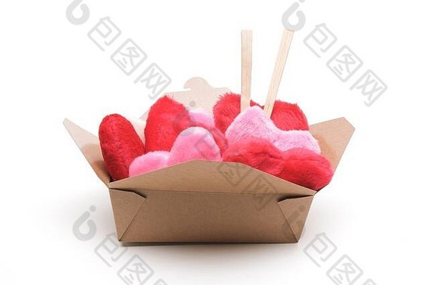 情人节静物画的概念是将蓬松的红色和粉红色的心放在一个棕色的带筷子的外卖盒里