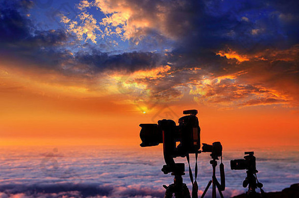 摄影者在云海上空的高山日落中工作